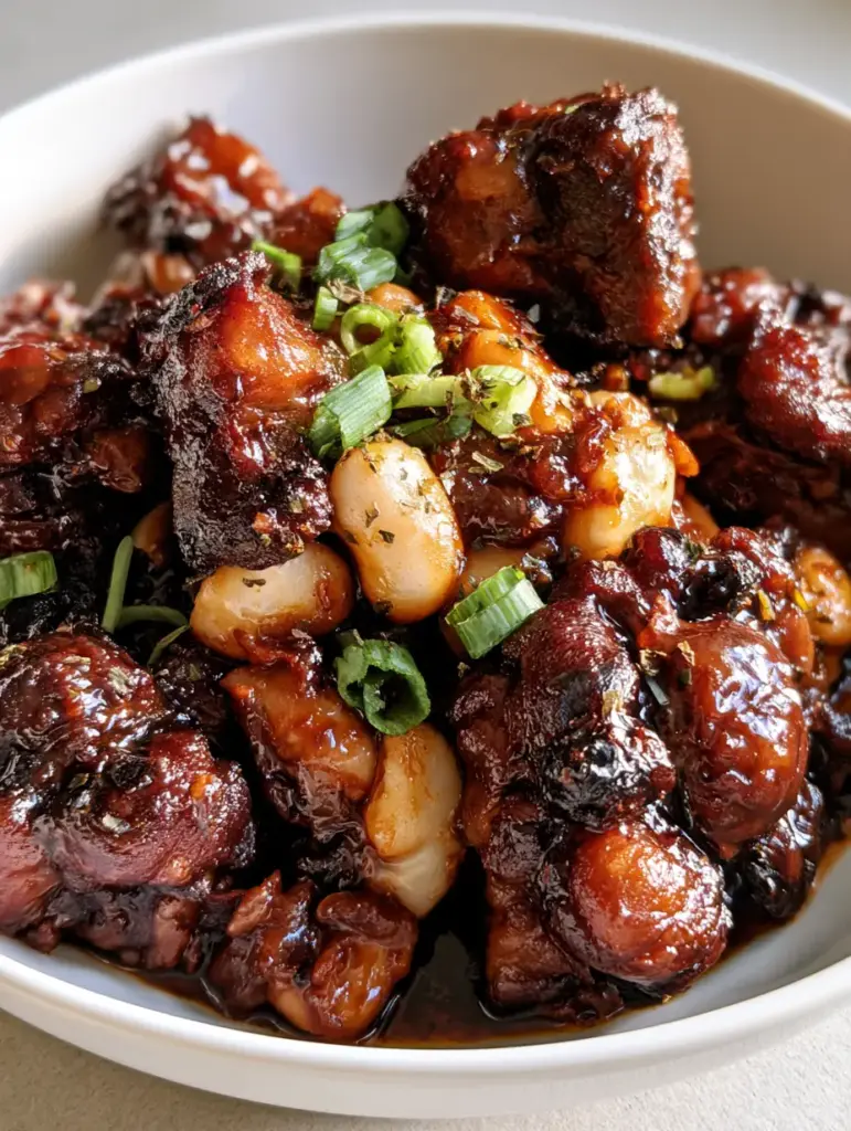 Authentic Jamaican Oxtail Recipe: Slow-Braised to Perfection 1 Top view of Authentic Jamaican Oxtail served with creamy butter beans and fresh green onions.