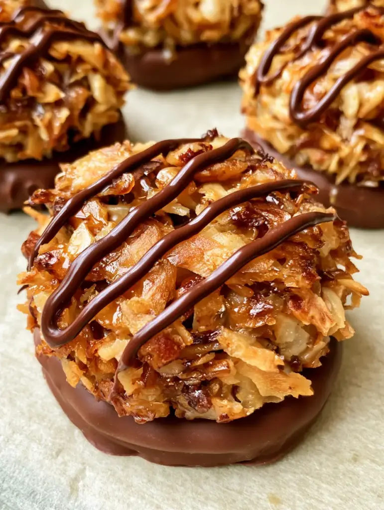 Close-up of ring-shaped No-Bake Samoa Cookies showing the thick layer of toasted golden shredded coconut and dark chocolate drizzle.