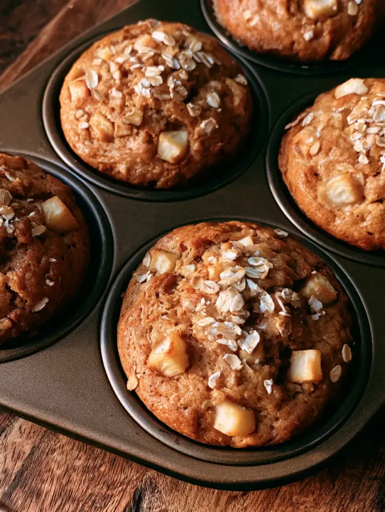 Detailed view of the golden-brown crust and diced fresh apple pieces inside the Apple Cinnamon Greek Yogurt Muffins.